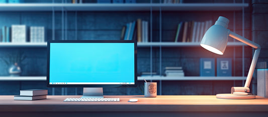 Bureau avec écran d’ordinateur et lampe de bureau