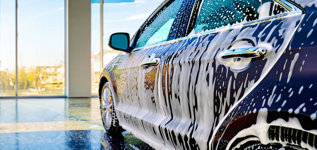 Carrosserie de voiture couverte de mousse lors d'un lavage écologique en intérieur.